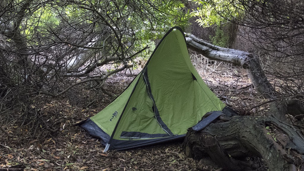 A l’intérieur de la tente, un Samuel en attente, lisant jusqu'au coucher du soleil Bivouac caché en forêt, frissons garantis !